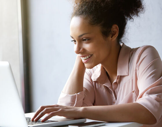 Young casual black woman at computer